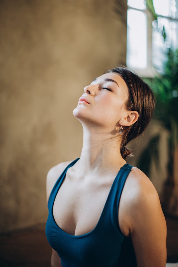 Tranquil indoor portrait of a woman in a calm and peaceful state with eyes closed.